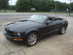 a black mustang parked in a parking lot