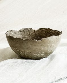 a stone bowl sitting on top of a white cloth