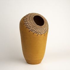 a brown vase sitting on top of a white table