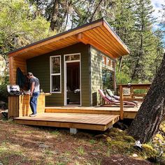 a man standing on the porch of a tiny cabin