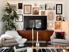 a living room with pictures on the wall and a television in the corner, surrounded by furniture