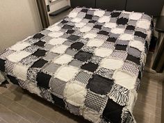 a black and white checkered quilt on a bed in a room with tile flooring