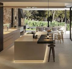 a modern kitchen with an island counter and bar stools