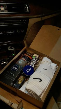 an open box with some items inside of it on a table next to a car radio