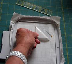 a person is cutting up a piece of paper with a knife and ruler next to it