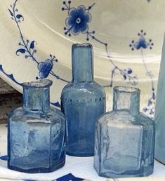 three blue vases sitting on top of a table next to a plate and napkin