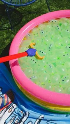 an inflatable pool filled with green liquid and plastic toys on top of it