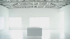 an empty white room with two windows and a box on the floor in front of it