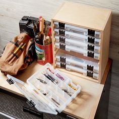 an assortment of crafting supplies sitting on top of a workbench with tools