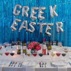 a table is set up with wine glasses and silverware for a festive event