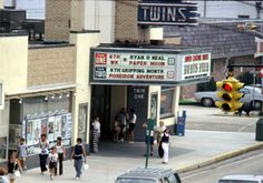 people are walking on the sidewalk in front of shops