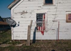 an old white house with the american flag painted on it's door and window