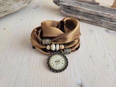 a close up of a watch on a wooden surface with other items in the background