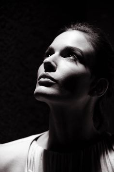 a black and white photo of a woman with her head tilted to the side looking up