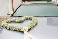 a heart shaped wreath on the hood of a car