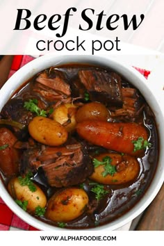 beef stew with potatoes and parsley in a white bowl on a red checkered tablecloth