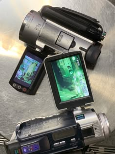 a video camera sitting on top of a metal table next to a cell phone and other electronic devices