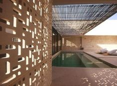 an indoor swimming pool in the middle of a building with perfored roofing