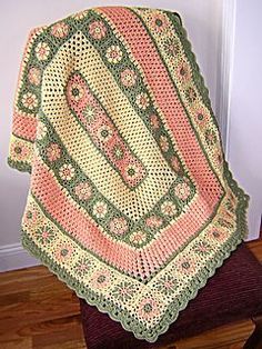 a crocheted blanket sitting on top of a wooden chair next to a door