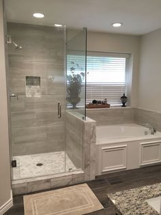 a bathroom with a walk in shower next to a bath tub