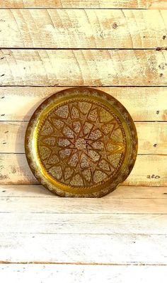 a brown plate sitting on top of a wooden table next to a wall with wood planks