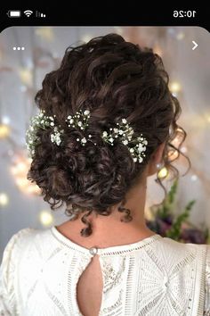 the back of a woman's head with flowers in her hair and pearls on it