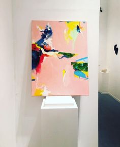 an abstract painting on display in a white room