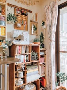 a sewing machine sitting on top of a wooden shelf next to a window in a room