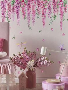 a bedroom with pink furniture and flowers hanging from the ceiling, along with wallpaper