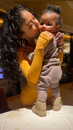 a woman kissing a baby on the cheek