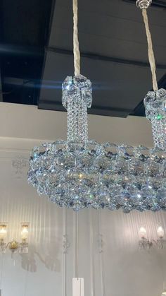 a chandelier hanging from the ceiling in a room with white walls and lights