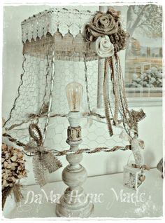 an old fashioned light fixture is decorated with lace and burlucks on it