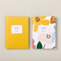 two notebooks sitting side by side next to each other