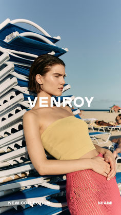 a woman standing on top of a beach next to blue and white chairs with the words ven roy