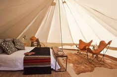 a bed with pillows and blankets in a tent