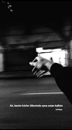 black and white photograph of a person holding their hand out in front of the camera