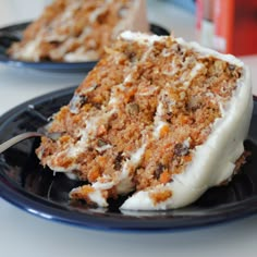 a slice of carrot cake with white frosting on a black plate next to a fork