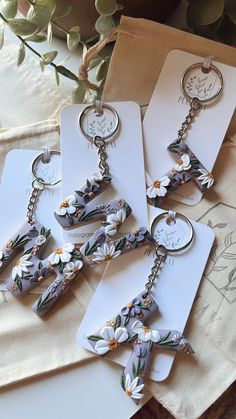 three keychains with flowers on them sitting next to each other in front of a card