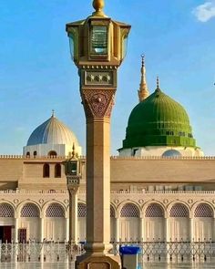 a tall clock tower in front of a building with domes on it's sides