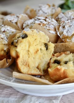 muffins and other pastries on a plate with powdered sugar toppings