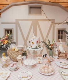 a table topped with plates and bowls filled with food next to a wall covered in flowers