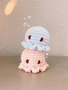 two small crocheted toys sitting on top of a table