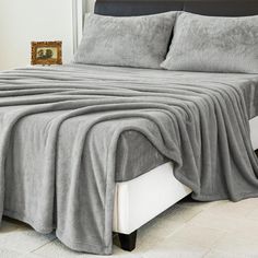 a bed with a gray blanket on top of it