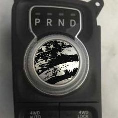 a black and white clock with the word prnd on it's face in front of an american flag