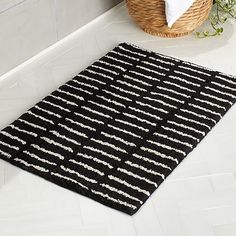 a black and white rug on the floor next to a basket