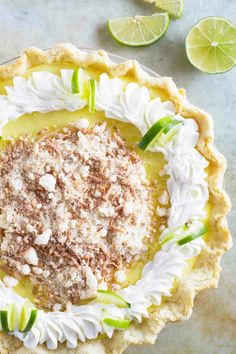 a pie topped with whipped cream and sliced limes