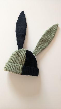 a knitted hat with two green and black ears