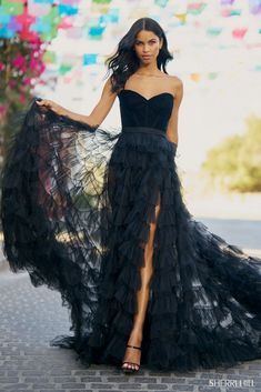 a woman in a black dress posing for the camera