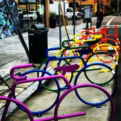 colorful bicycle racks are lined up on the sidewalk