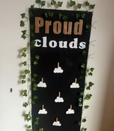 a sign that says proud clouds on the side of a wall with ivy growing around it